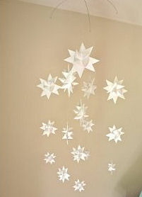 Star theme baby crib mobile with white paper origami stars hung on a wire frame