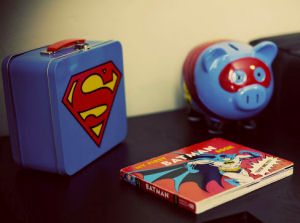 Vintage Superman lunchbox, bank and Batman book are decorations for the baby's nursery