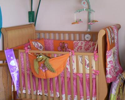 The crib with its pink and orange surf theme baby bedding set that we chose our baby girl's surfer nursery 