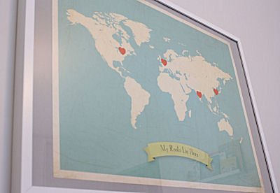 Map artwork on the baby's nursery wall with countries of ancestry marked with hearts