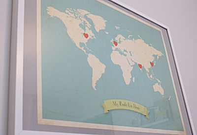 Map artwork on the baby's nursery wall with countries of ancestry marked with hearts