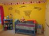 Our favorite Dr Seuss quotes and red and white wallpaper border decorate the wall above the baby's crib