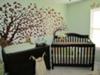 Mystical forest baby nursery theme.  The baby's room has its own cherry tree wall mural surrounded with baby deer, birds and other woodland creatures.  The soft sage green nursery walls make the space so peaceful.