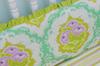 A baby girl's bedding set with ruffles in orchid purple, emerald green and gold.  