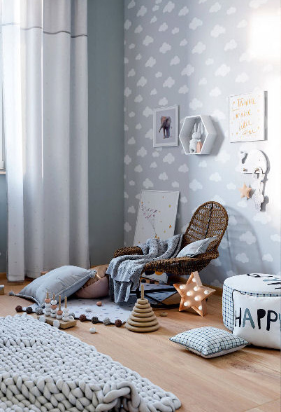 Reading nook in a baby blue cloud themed baby room for a boy.