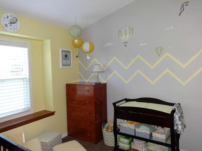 Full view of our baby girl's grey and yellow nursery room and the painted chevron wall stripes that got the entire family involved in the decorating process