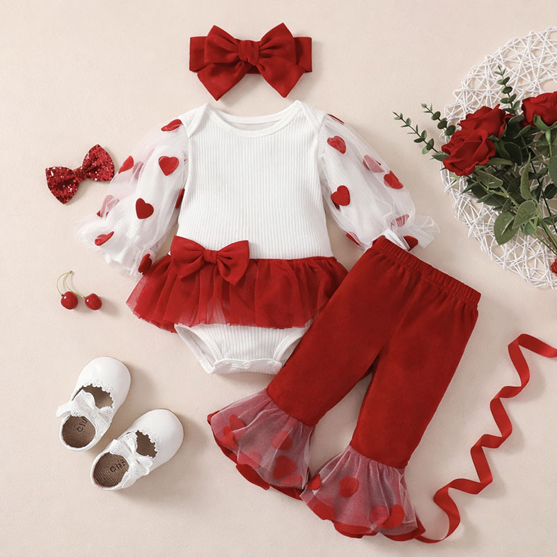 Valentine onesies for baby girls styled in soft red, blush, and cream tones with coordinated accessories