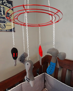 Homemade DIY baby crib mobile hanging with vintage garage tools decorations.