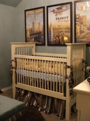 A baby boy nursery room decorated in a vintage travel theme with antique framed transportation posters