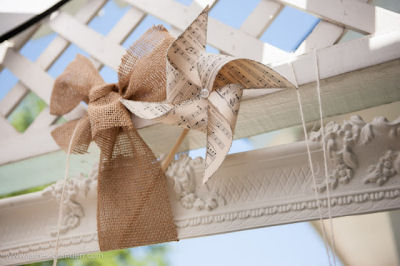 Homemade pinwheels made from vintage sheet music decorated with rustic burlap bows