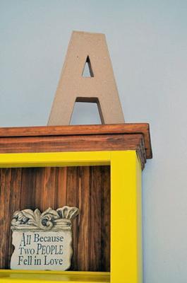 Asher's initial displayed on the bright yellow bookshelf made made with love by my step father in law, Gary