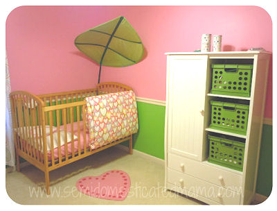 A white nursery armoire holds lime green storage bins