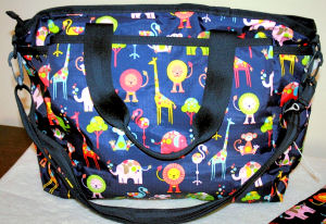 Satchel style baby diaper bag in navy blue with a zoo animals pattern